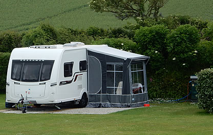 Touring caravan with awning on camping pitch at Looe Country Park